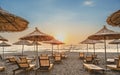 Sunshade beach umbrellas with sunset sky and sea background. Sarande, Albania