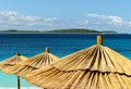 Sunshades and chairs on turquoise adriatic beach. Royalty Free Stock Photo