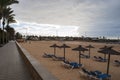 Sunshades and deckchairs on an empty beach