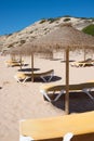 Sunshades and yellow deck chairs in a row with no people. Algarve, Portugal Royalty Free Stock Photo