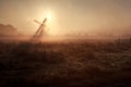 Sunshine behind windmill in misty morning