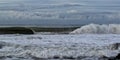 Sunshine Coast with crashing waves during a storm under a blue cloudy sky