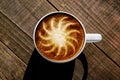 Sunshine Latte Art in Cup on Rust Colored Wooden Table