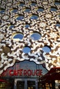 Cafe Rouge under the impressive geometric facade of Ravensbourne University. Greenwich Peninsular, London.