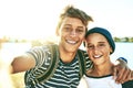 Sunshine always makes for a good selfie. Cropped portrait of two young brothers taking selfies outside with a lagoon in