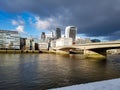 Sunshine spot lightning skyscraper building London office business district bridge dark clouds break up sun come through