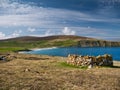 With sunshine on turquoise water and an old stone enclosure a planticrub on the right, the pristine, deserted Norwick beach Royalty Free Stock Photo