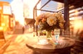 Sunshine white roses cup of coffee and blue glass of wine on wooden table at street cafe plant shadow sunlight reflection on