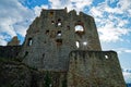 Sunstar in small window of medieval castle ruin against blue sky with white clouds