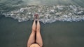 Suntan beach woman tanning legs relaxing swimming in ocean water with sunset Royalty Free Stock Photo