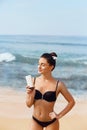 Suntan Lotion. Sexy Young Woman Applying Sunscreen Solar Cream on the beach.Sun Protection. Sun Cream. Skin and Body Care.Girl Hol Royalty Free Stock Photo