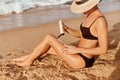 Suntan Lotion. Sexy Young Woman Applying Sunscreen Solar Cream on the beach.Sun Protection. Sun Cream.