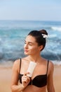 Suntan Lotion. Sexy Young Woman Applying Sunscreen Solar Cream on the beach.Sun Protection. Sun Cream. Skin and Body Care.Girl Hol Royalty Free Stock Photo