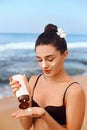 Suntan Lotion. Sexy Young Woman Applying Sunscreen Solar Cream on the beach. Royalty Free Stock Photo