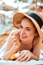 Suntan woman in hat applying sunscreen solar. Beautiful happy woman smear lotion with sun cream to her nose.Ski care Royalty Free Stock Photo
