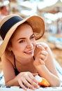 Suntan   woman in hat applying sunscreen solar. Beautiful happy woman smear  lotion  with sun cream   to her nose Royalty Free Stock Photo