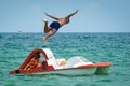 Suntanned man jumping from the pedal boat in the sea water. Royalty Free Stock Photo