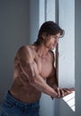 Suntanned muscular male in blue jeans posing. Royalty Free Stock Photo