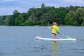 SUP Stand up paddle board concept - Pretty, young woman paddle boarding on a  lake Royalty Free Stock Photo