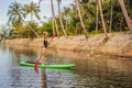 SUP Stand up paddle board woman paddle boarding on lake standing happy on paddleboard on blue water. Action Shot of Royalty Free Stock Photo