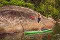 SUP Stand up paddle board woman paddle boarding on lake standing happy on paddleboard on blue water. Action Shot of Royalty Free Stock Photo