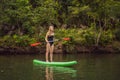 SUP Stand up paddle board woman paddle boarding on lake standing happy on paddleboard on blue water. Action Shot of Royalty Free Stock Photo