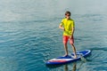 Sup surfing man stand up paddle boarder paddling at sunset on river Royalty Free Stock Photo