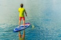 Sup surfing man stand up paddle boarder paddling at sunset on river Royalty Free Stock Photo