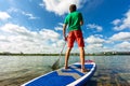 Sup surfing man stand up paddle boarder paddling at sunset on river Royalty Free Stock Photo