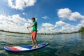 Sup surfing man stand up paddle boarder paddling at sunset on river Royalty Free Stock Photo