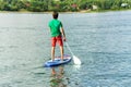 Sup surfing man stand up paddle boarder paddling at sunset on river Royalty Free Stock Photo