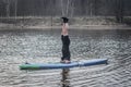SUP YOGA, a man in a wetsuit doing yoga on a cloudy day, headstand on a paddle Board Royalty Free Stock Photo