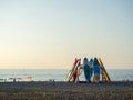 Supboards stacked on the beach at sunset. Swimming boards are stacked in a pyramid. Rest on the sea. Business on the resort beach