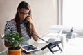 Super busy... But thats good news. a young businesswoman talking on the phone while using a digital tablet. Royalty Free Stock Photo