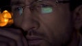 Super close-up of businessman face, male in eyeglasses looking at PC screen