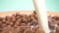 Super close up. milk is poured into breakfast cereals chocolate corn balls Royalty Free Stock Photo