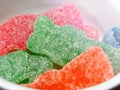 Super close up of orange, red, and green gummy candy