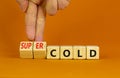 Super cold symbol. Doctor turns wooden cubes and changes concept words cold to super cold. Beautiful orange table, orange