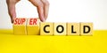 Super cold symbol. Doctor turns wooden cubes and changes concept words cold to super cold. Beautiful yellow table, white