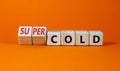 Super cold symbol. Turned wooden cubes and changed concept words cold to super cold. Beautiful orange table, orange background,