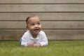 Super cute little baby model laughing and lying on belly in the Royalty Free Stock Photo