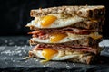 super delicious sandwich stack, with bacon, eggs and avocado, in black background. Royalty Free Stock Photo