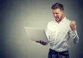 Super excited young man with laptop computer Royalty Free Stock Photo