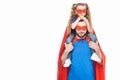 super father carrying little daughter in mask and cloak and looking at camera