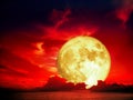 Super full blood moon over silhouette heap cloud on sea Royalty Free Stock Photo