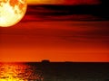 super full blood moon ship dark sea sunset sky Royalty Free Stock Photo