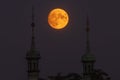 Super full moon just after rising between the two towers of the church Royalty Free Stock Photo