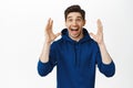 Super happy guy screams of joy, smiling and looking amazed at camera, winning prize, surprised by great news, standing Royalty Free Stock Photo