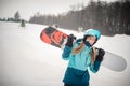 Super happy woman laughing whilst getting ready to go snowboarding