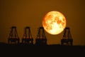 super harvest moon on night sky back  over silhouette cranes in seaport Royalty Free Stock Photo